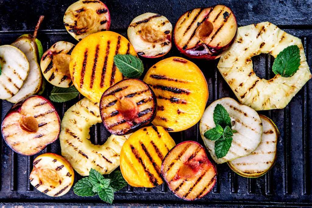 shutterstock_1050552731_Grillobst Grillrost an, Früchte drauf und staunen! Denn Wassermelone, Ananas, Pfirsich & Co. verwandeln sich auf dem Grill in kleine Sommerstars mit goldenen Röstaromen. Blitzschnell gemacht, herrlich saftig und so lecker, dass garantiert niemand nach dem Nachtisch fragt – weil er längst auf dem Rost liegt!